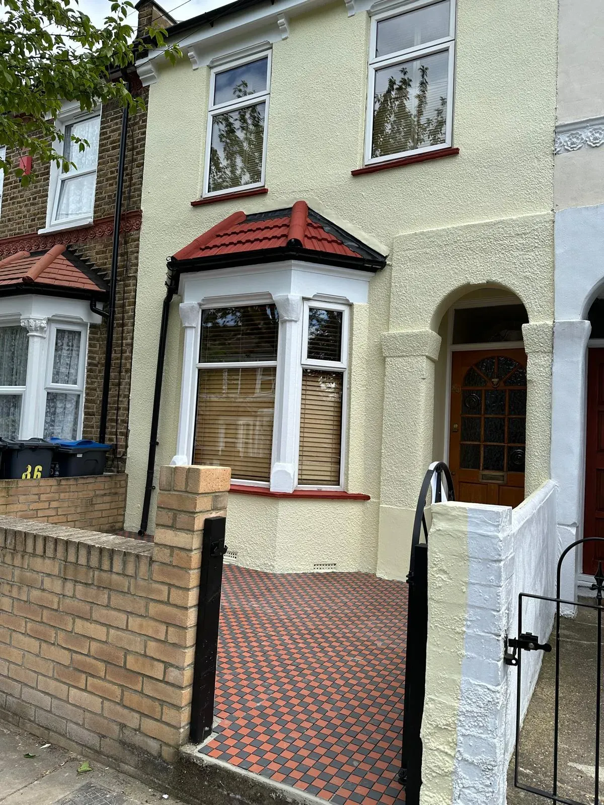 Front of a house with fresh cream paint and a new checkered block paving entrance